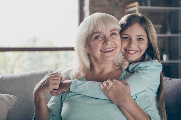 Little girl and grandmother sitting on the couch