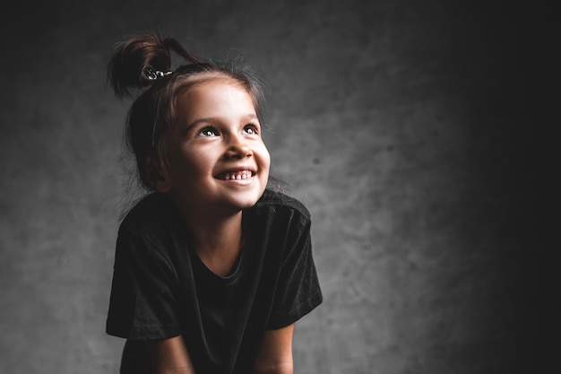 Little girl on a gray background. Portrait in beautiful colors