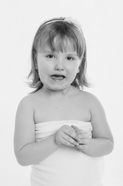 Photo a little girl grimaces against a white background.