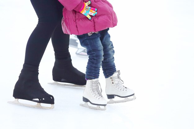 얼음 위에서 스케이트를 타는 어린 소녀와 어른