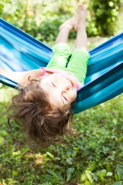 Photo little girl in a hammock enjoys the summer