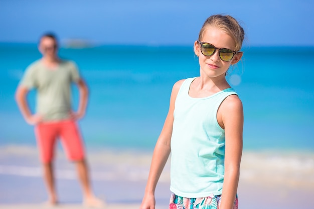 Little girl and happy dad having fun during beach vacation