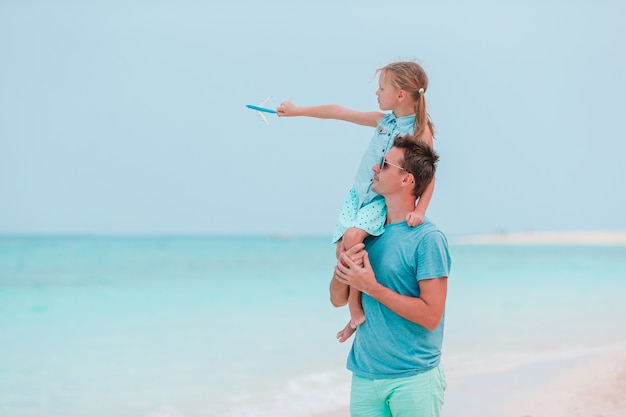 Little girl and happy dad having fun during beach vacation