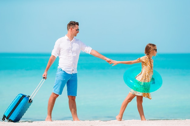 Little girl and happy dad having fun during beach vacation