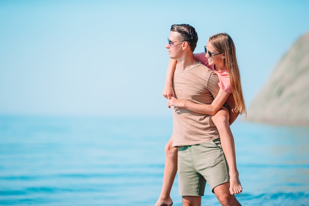 Little girl and happy dad having fun during beach vacation