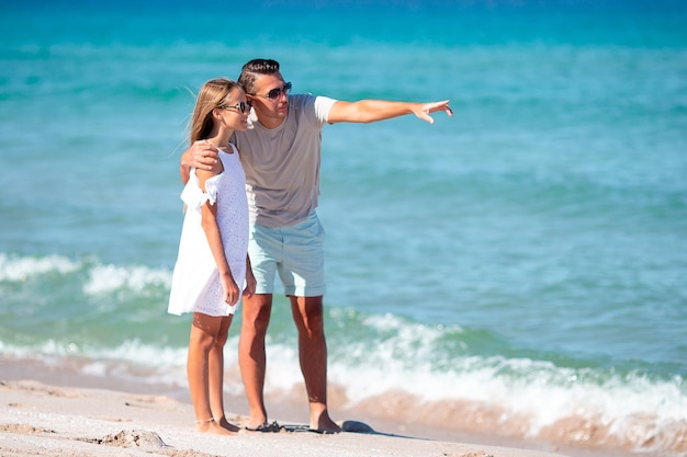 Little girl and happy dad having fun during beach vacation