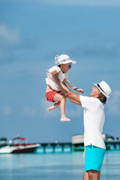 Little girl and happy dad having fun during beach vacation