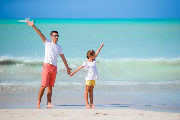 Bambina e papà felice divertendosi durante la vacanza della spiaggia