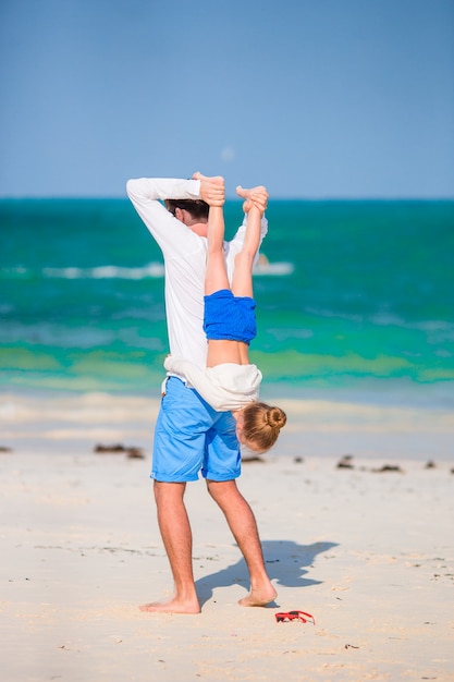 Bambina e papà felice divertendosi durante la vacanza della spiaggia