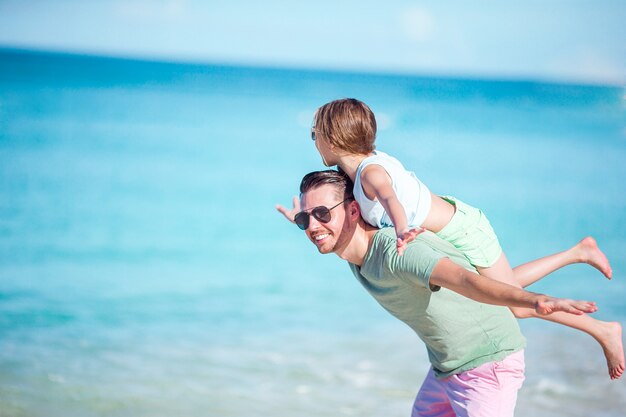 Bambina e papà felice divertendosi durante la vacanza della spiaggia