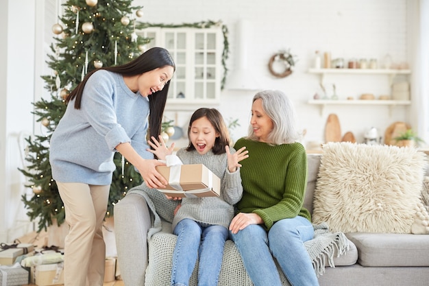 クリスマスの日に彼女の姉からプレゼントを与えることに満足している少女