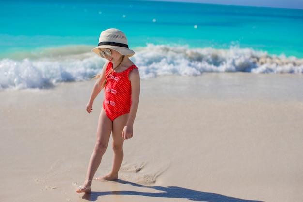 Little girl in hat at beach during caribbean vacation