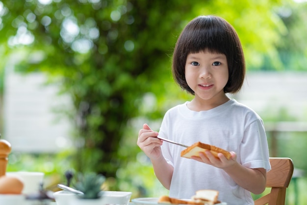 小さな女の子は朝食を食べます幸せなtimexA