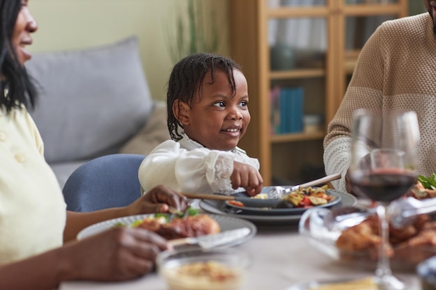 Little girl having dinner with family