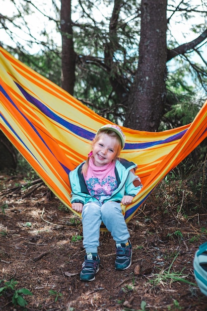 Little girl having fun at hammock smiling toddler child