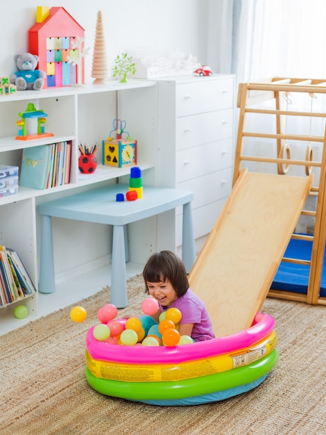 Little girl having fun riding a roller coaster on a wooden home sports gaming complex stairs