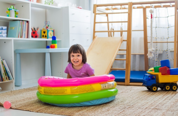 Little girl having fun riding a roller coaster on a wooden home\
sports gaming complex stairs