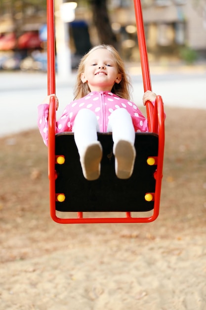 Little girl having fun on swing outdoor