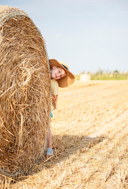 Little girl having fun in a wheat field on a summer day