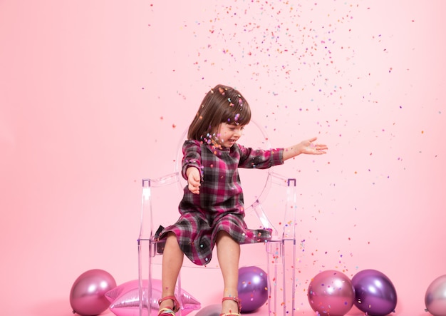 Little girl having fun with confetti. The concept of celebration and fun.