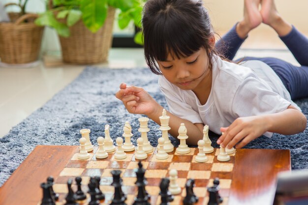 Little girl having online chess lesson, e-education, distance learning