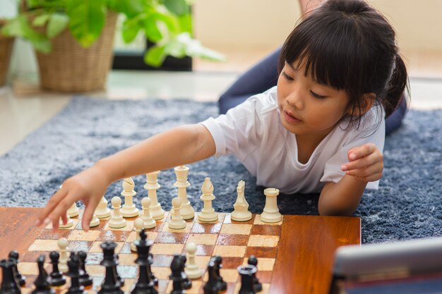 Little girl having online chess lesson, e-education, distance learning