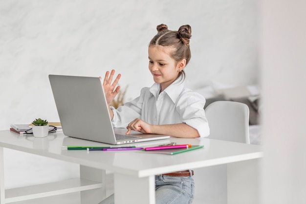 Photo little girl having an online class