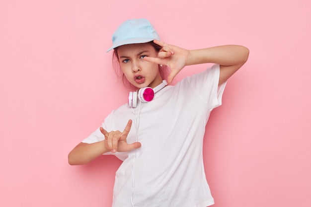 白いTシャツとキャップの子供時代の変更されていない小さな女の子のヘッドフォン