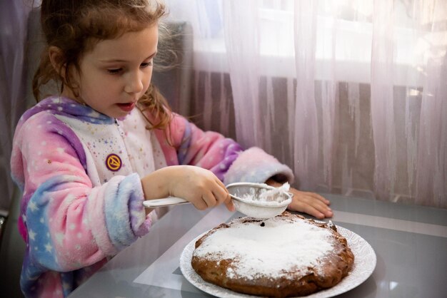 小さな女の子がアップルパイを作るのを手伝います。