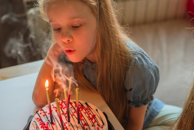 A little girl on her birthday sits on the floor next to\
scattered confetti from a festive hatxachild celebrates his\
birthday at home during illness quarantine isolation holiday\
without guests