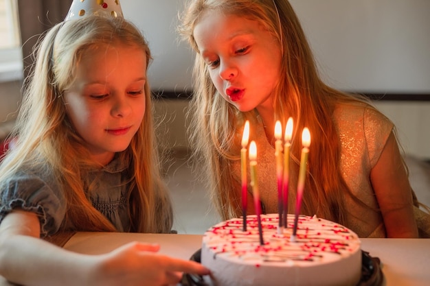 A little girl on her birthday sits on the floor next to\
scattered confetti from a festive hatxachild celebrates his\
birthday at home during illness quarantine isolation holiday\
without guests