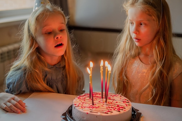 A little girl on her birthday sits on the floor next to\
scattered confetti from a festive hatxachild celebrates his\
birthday at home during illness quarantine isolation holiday\
without guests