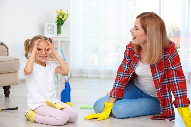 Little girl and her mother playing while doing cleanup at home