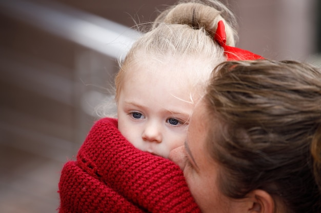 Little girl in her mother's arms. close-up