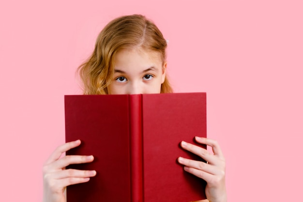 little girl hiding over a book