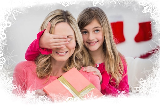 Little girl hiding gift from mother against frost frame