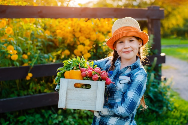 Little girl holding basket with fresh organic vegetables