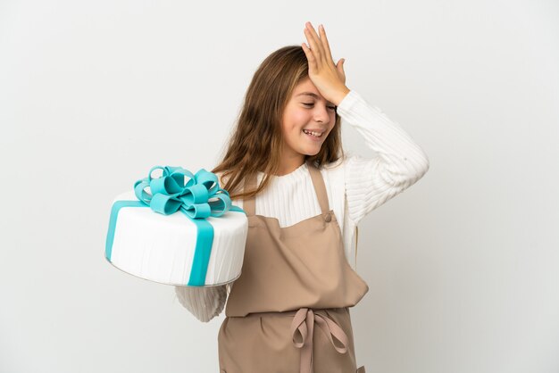 Little girl holding a big cake over isolated white background has realized something and intending the solution