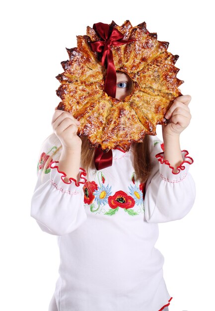 Фото Маленькая девочка держит большую рождественскую звезду, традиционный десерт. украинский калита