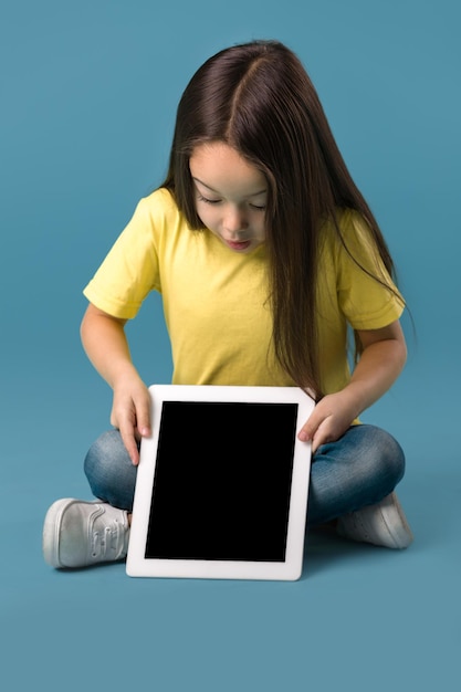 little girl holding a blank tablet computer