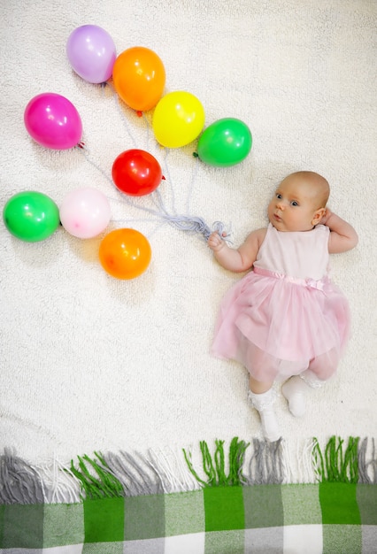 Little girl holding a bunch of balloons and a flight shows