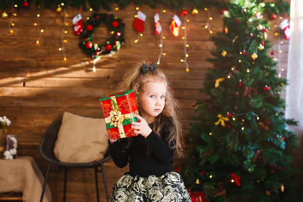 Маленькая девочка держит рождественскую подарочную коробку
