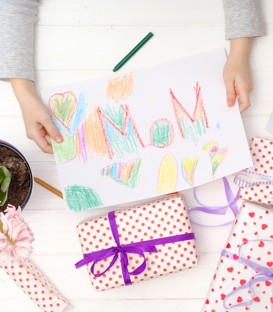 Little girl holding craft card for happy mother celebration day