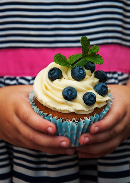 写真 小さな女の子ホールディングカップケーキ