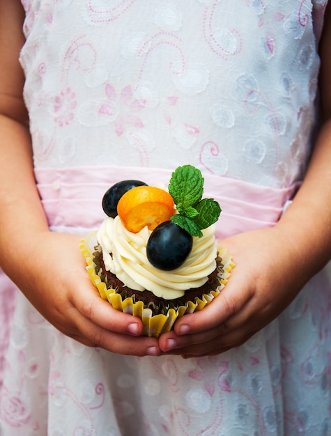 Little girl holding cupcake