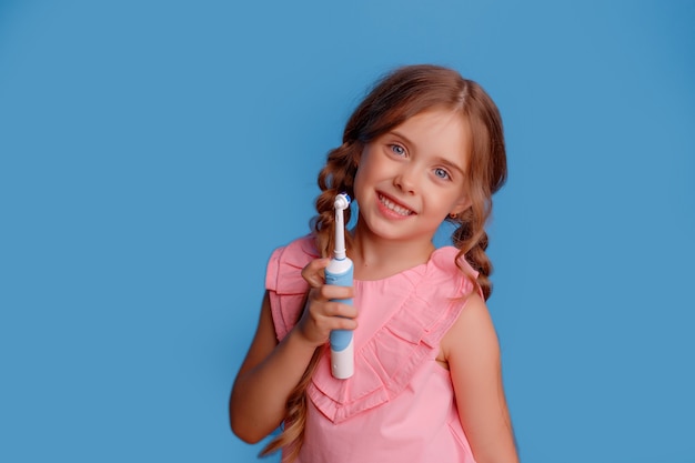 Маленькая девочка держит электрическую зубную щетку