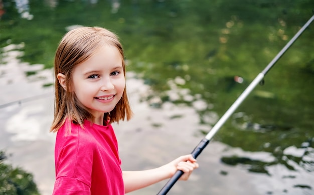 Premium Photo  Little girl holding fishing rod on pond background