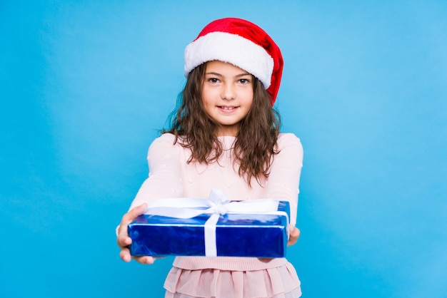 Little girl holding a gift celebrating christmas day