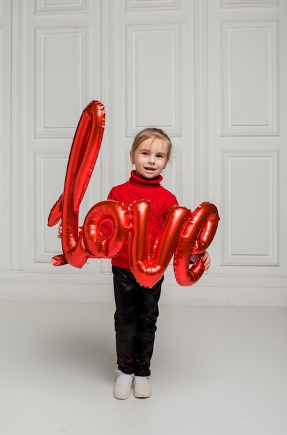 Little girl holding love balloon on white background with space for text