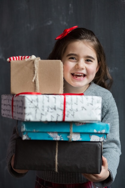 little girl holding New Year's gifts in her hands and rejoices